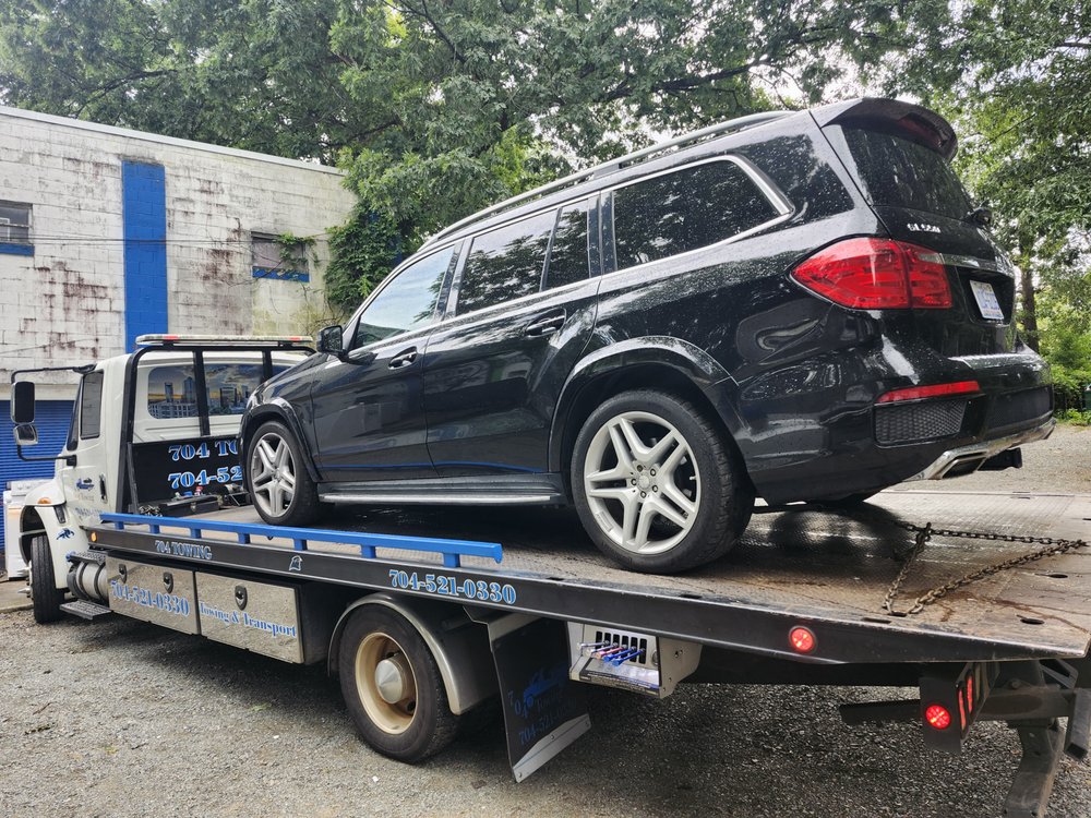 704 Towing flatbed transporting a Mercedes SUV